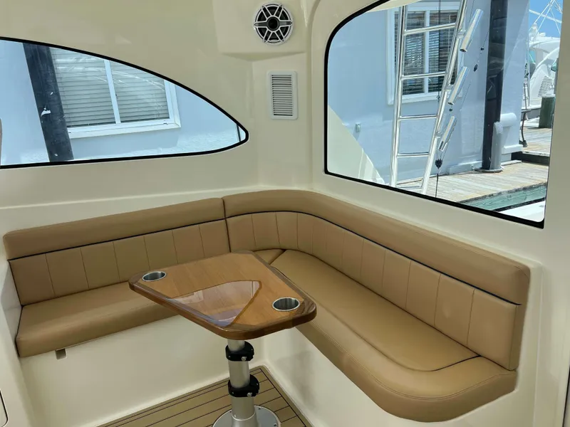 Slide: The Image of Interior of 2022 Henriques 42 Express Hardtop with tan seating and wooden table. - 47