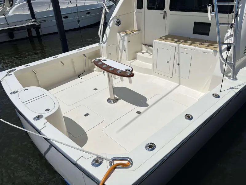 Slide: The Image of 2022 Henriques 42 Express Hardtop boat deck with fishing rod holders and seating. - 6