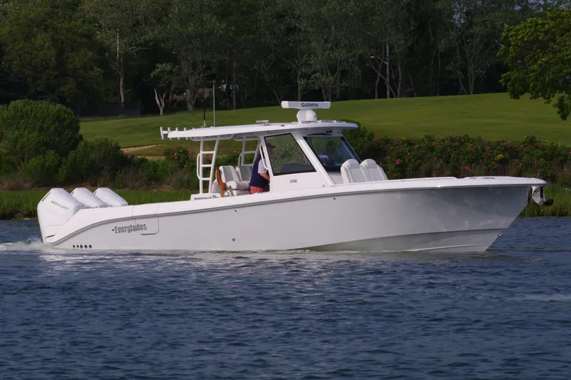 The Image of 2025 Everglades 375 Center Console boat cruising on a scenic waterway. - 0