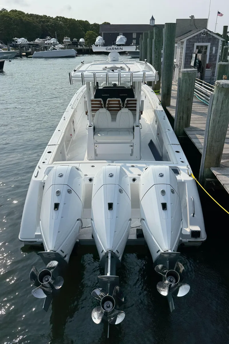 Slide: The Image of 2025 Everglades 375 Center Console boat docked with triple outboard engines. - 12