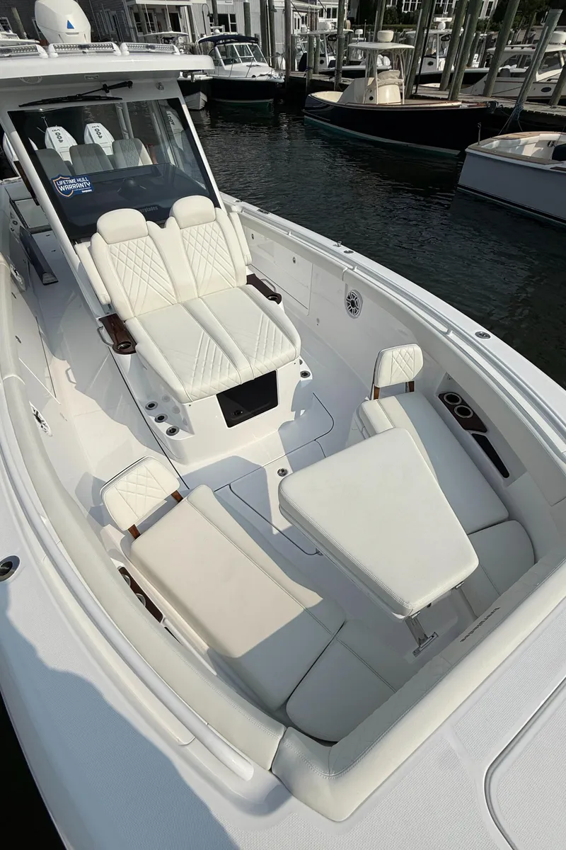 Slide: The Image of 2025 Everglades 375 Center Console boat with luxurious seating and sleek design at a marina. - 14