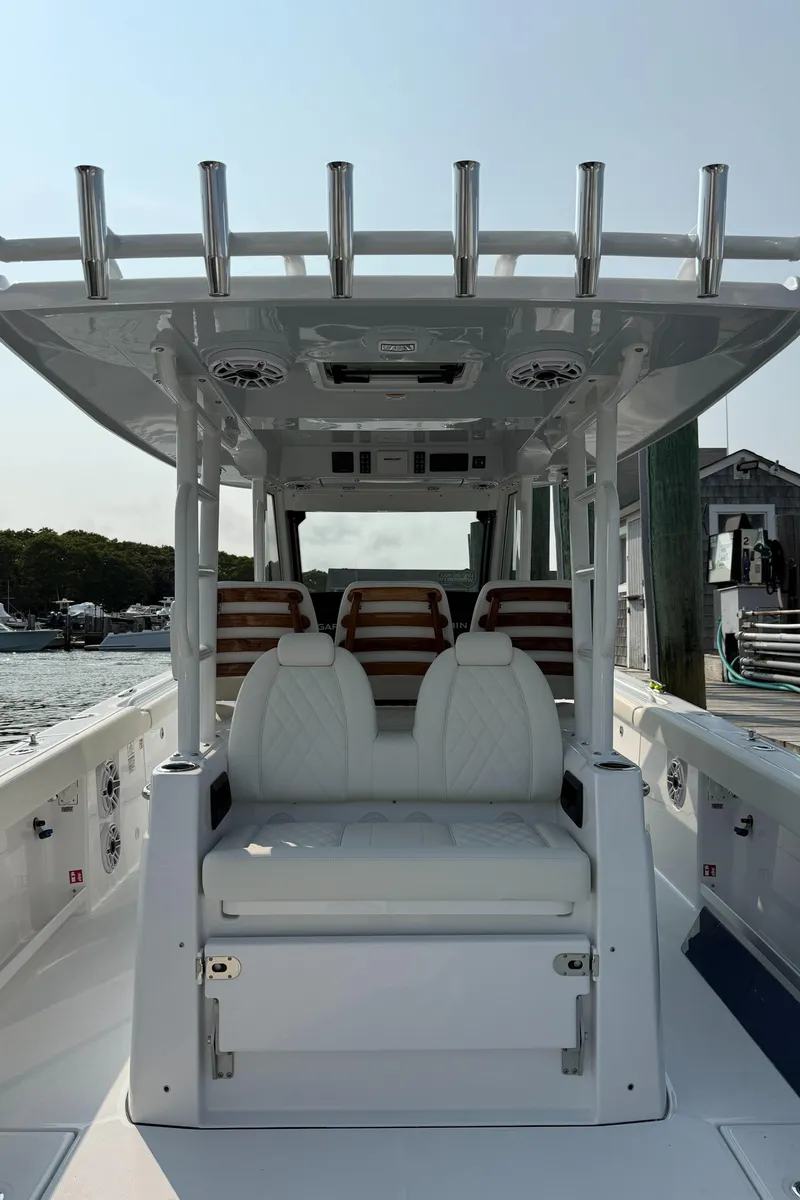 Slide: The Image of 2025 Everglades 375 Center Console boat with white seating and rod holders, docked at marina. - 18