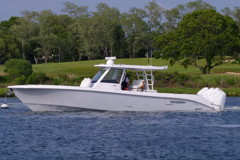 Slide: The Image of 2025 Everglades 375 Center Console boat cruising on a scenic waterway. - 7