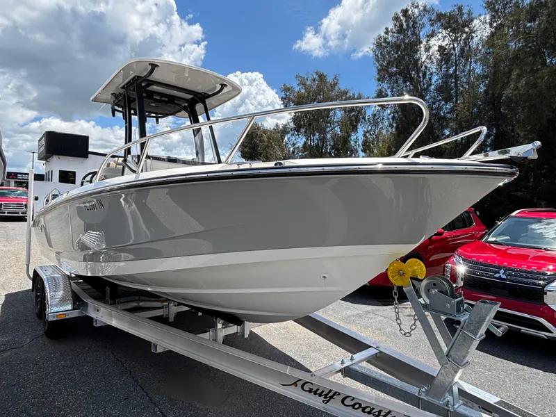 The Image of 2023 Boston Whaler 220 Dauntless boat on trailer, parked outdoors under a cloudy sky. - 0