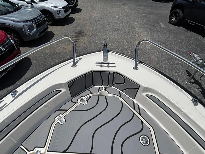 Slide: The Image of 2023 Boston Whaler 220 Dauntless boat deck with sleek design, parked near cars. - 11
