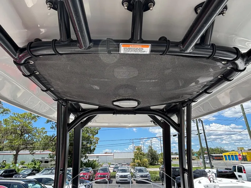Slide: The Image of T-top view of 2023 Boston Whaler 220 Dauntless boat, showcasing sturdy black framework. - 18