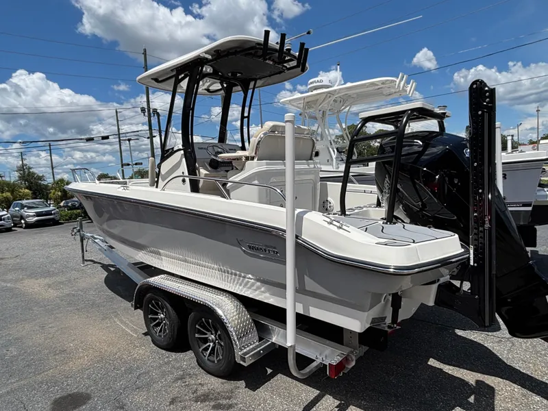 Slide: The Image of 2023 Boston Whaler 220 Dauntless boat on trailer under blue sky. - 2