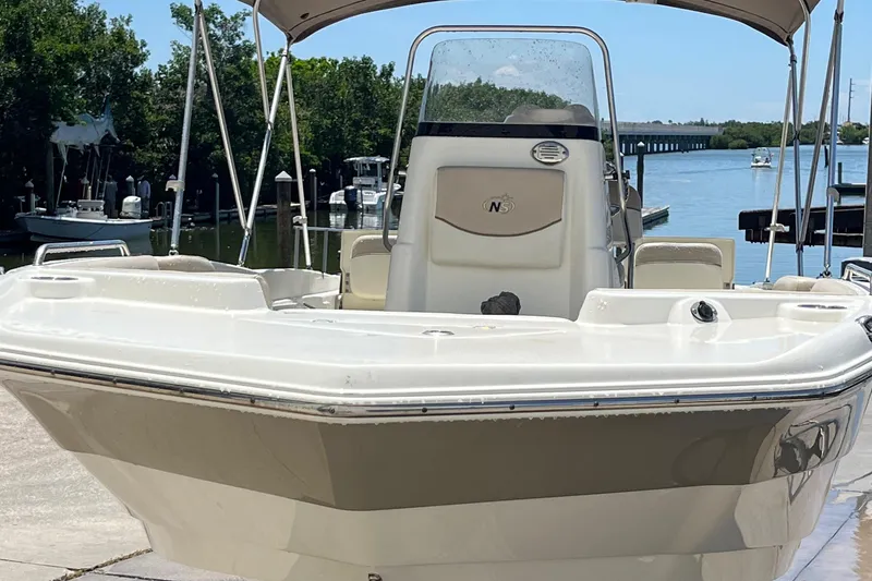 Slide: The Image of 2016 NauticStar 211 Angler boat docked by a scenic waterfront. - 10