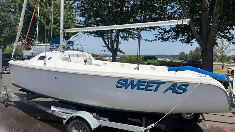 The Image of 2011 Marlow-Hunter 22 sailboat named "Sweet As" on a trailer, parked outdoors. - 0