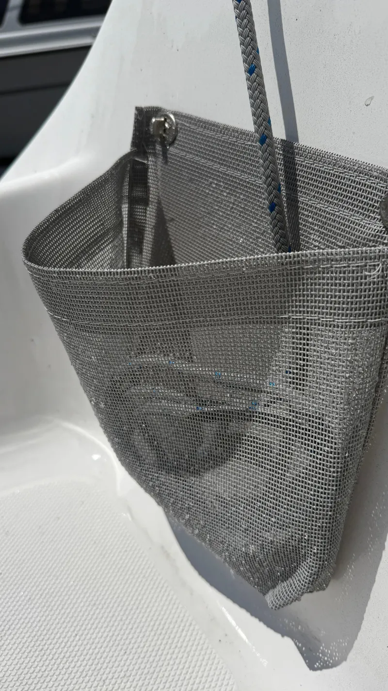 Slide: The Image of Mesh storage pocket on 2011 Marlow-Hunter 22 sailboat, holding a rope. - 10