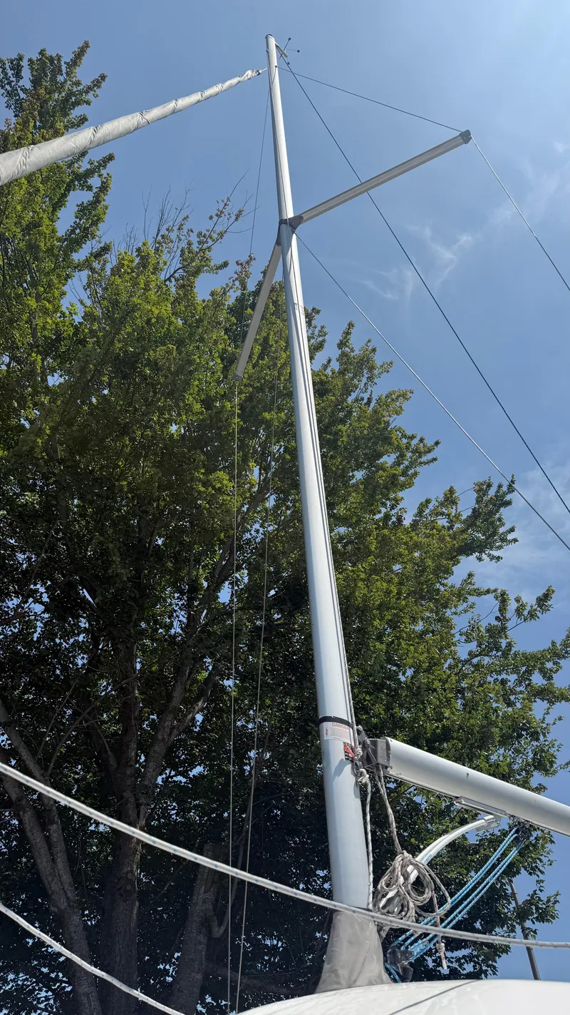 Slide: The Image of Marlow-Hunter 22 sailboat mast against blue sky and trees, 2011 model. - 6