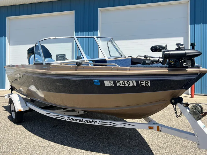 Slide: The Image of 1998 Lund 1700 Pro Sport Adventure boat on trailer, parked outside blue building. - 3