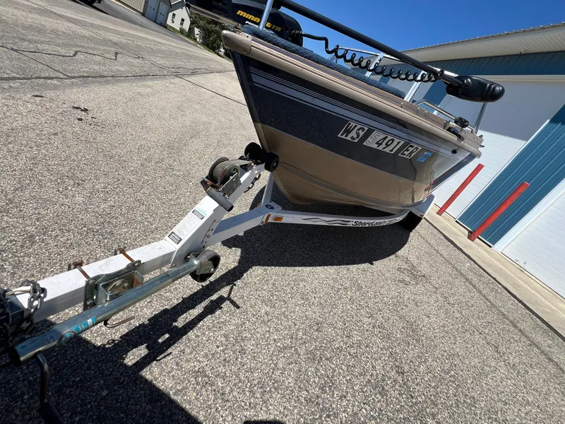 Slide: The Image of 1998 Lund 1700 Pro Sport Adventure boat on trailer, parked on asphalt near blue building. - 8