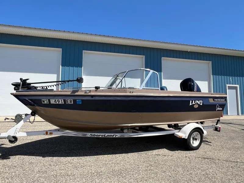 Slide: The Image of 1998 Lund 1700 Pro Sport Adventure boat on trailer, parked outside blue building. - 9
