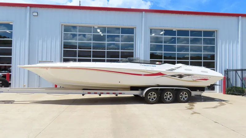 Slide: The Image of 2004 Fountain 35 Executioner boat on trailer, parked outside a garage. - 1