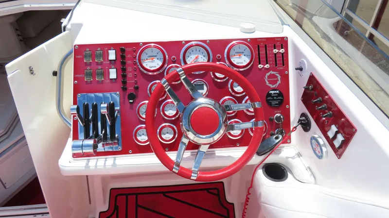 Slide: The Image of 2004 Fountain 35 Executioner boat dashboard with red steering wheel and control panel. - 11