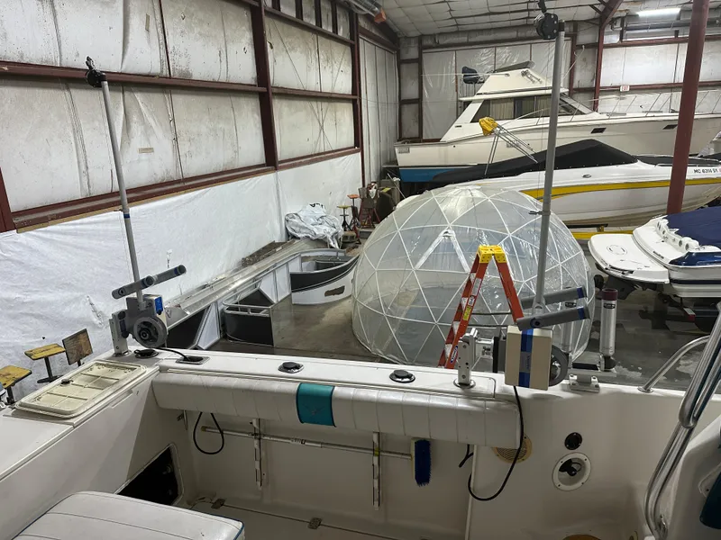 Slide: The Image of 1996 Pro-Line 251 Walkaround I/O in storage, surrounded by boats and equipment. - 10