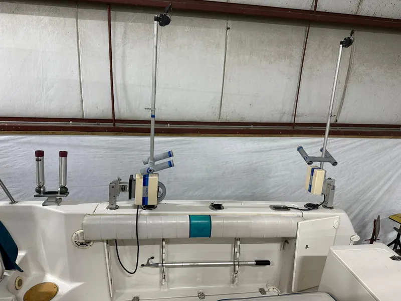 Slide: The Image of 1996 Pro-Line 251 Walkaround I/O boat interior with fishing rod holders and equipment. - 11