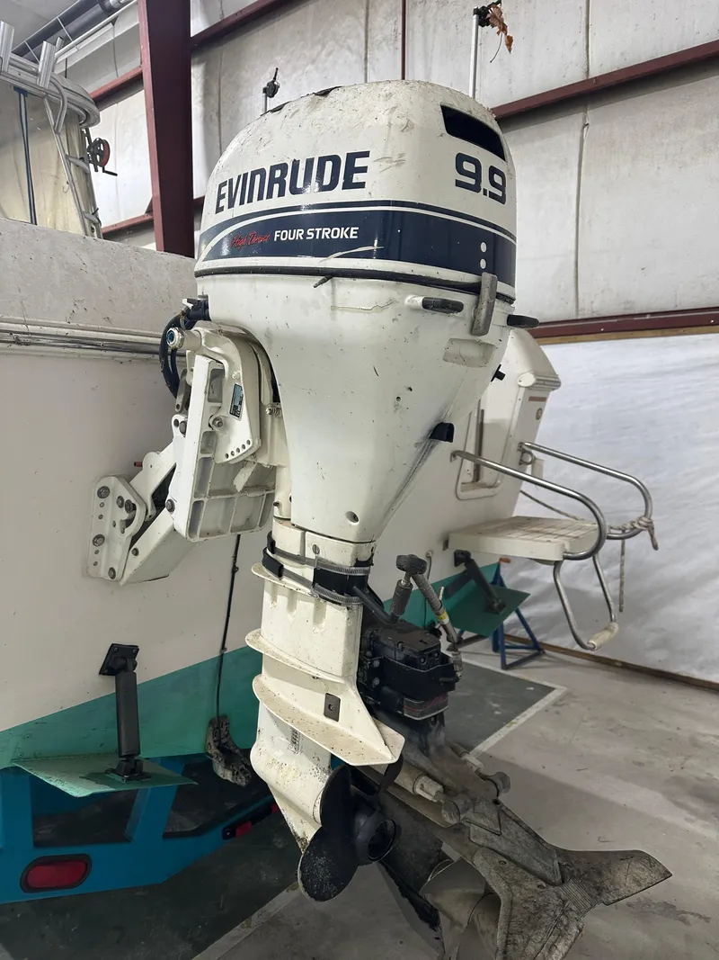 Slide: The Image of 1996 Pro-Line 251 Walkaround I/O with Evinrude 9.9 four-stroke outboard motor in storage. - 13