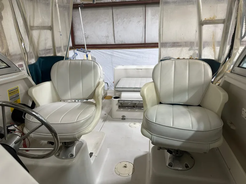 Slide: The Image of 1996 Pro-Line 251 Walkaround I/O boat interior with two white captain's chairs. - 19