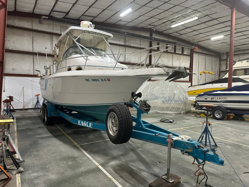 Slide: The Image of 1996 Pro-Line 251 Walkaround I/O boat on trailer in indoor storage facility. - 4