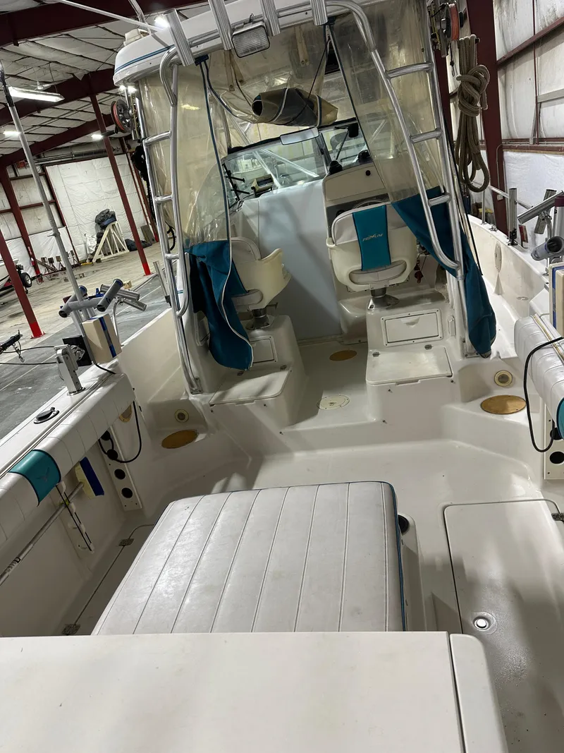 Slide: The Image of 1996 Pro-Line 251 Walkaround I/O boat interior with seating and fishing equipment. - 5