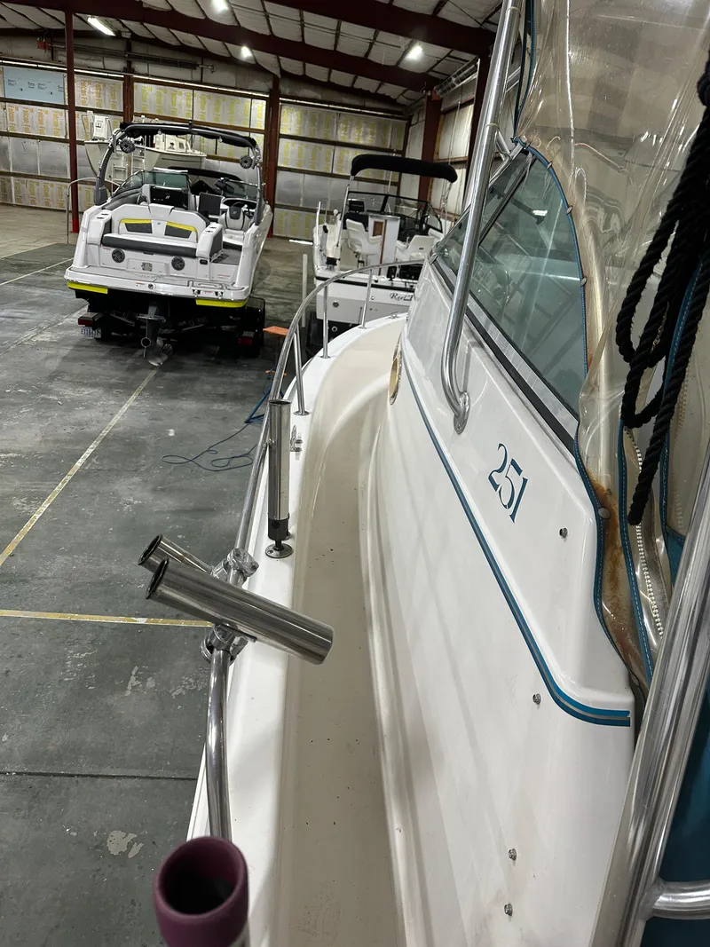 Slide: The Image of 1996 Pro-Line 251 Walkaround I/O boat in storage, side view with other boats. - 9