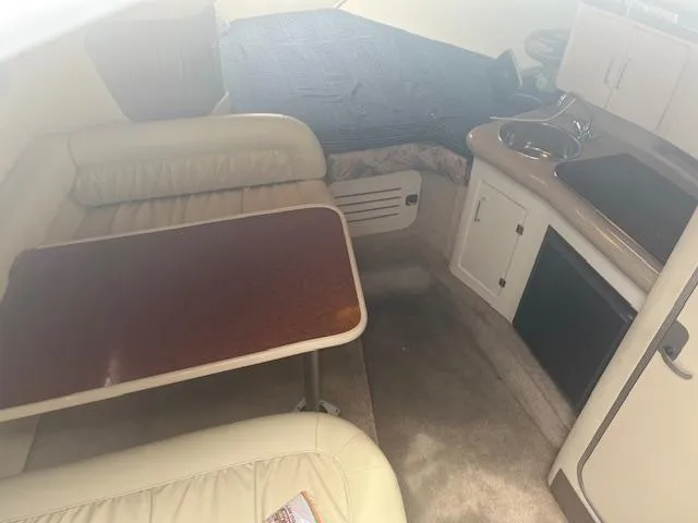 Slide: The Image of Interior of a 1997 Monterey 296 Cruiser with seating, table, and kitchenette. - 12