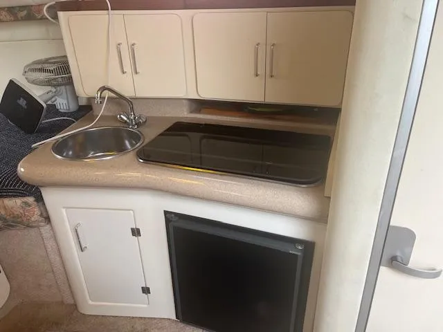 Slide: The Image of Compact kitchen area in a 1997 Monterey 296 Cruiser with sink, stove, and storage cabinets. - 15