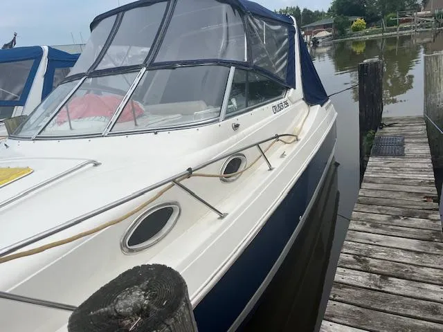 Slide: The Image of 1997 Monterey 296 Cruiser docked by a wooden pier on a calm lake. - 3