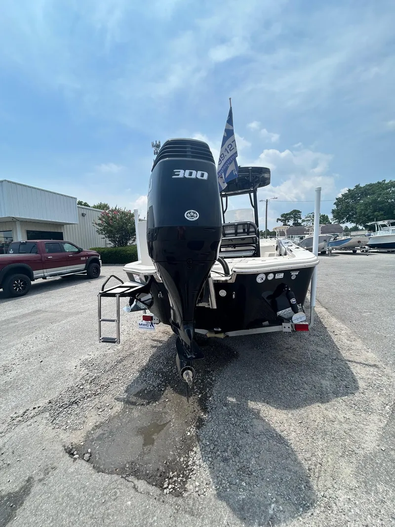 Slide: The Image of 2025 Sea Chaser 26 LX boat with powerful 300 HP engine, parked outdoors. - 12