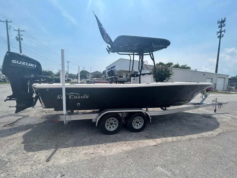 Slide: The Image of 2025 Sea Chaser 26 LX boat on trailer with Suzuki outboard motor, parked outdoors. - 3
