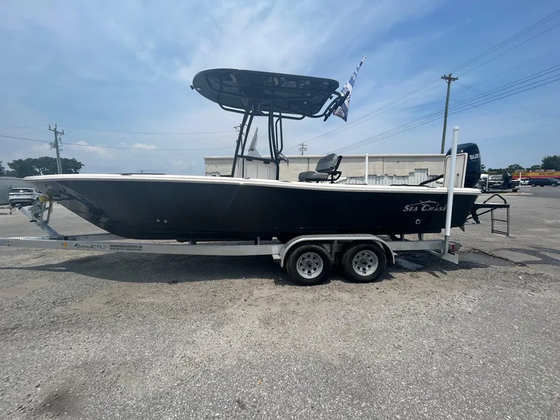 Slide: The Image of 2025 Sea Chaser 26 LX boat on trailer, parked outdoors under clear sky. - 5