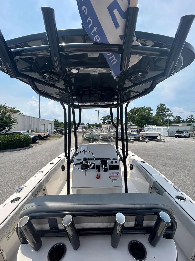 Slide: The Image of 2025 Sea Chaser 26 LX boat interior with steering console and rod holders. - 6