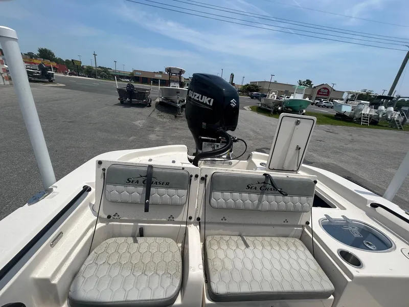Slide: The Image of 2025 Sea Chaser 26 LX boat with Suzuki engine, parked in a lot. - 8