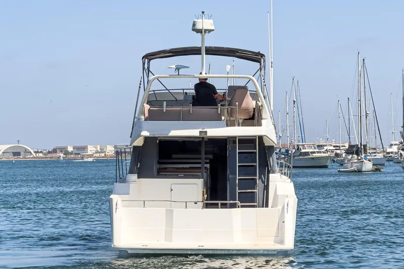 Slide: The Image of 1992 Bayliner 4388 yacht cruising in a marina, surrounded by sailboats. - 11