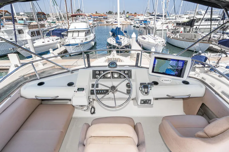 Slide: The Image of Cockpit view of 1992 Bayliner 4388 yacht with marina background. - 13