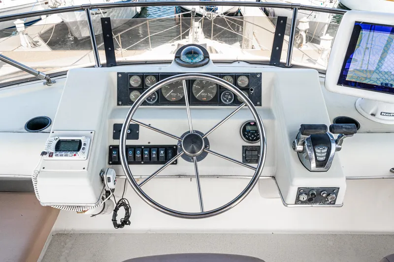 Slide: The Image of 1992 Bayliner 4388 helm with steering wheel, gauges, and navigation equipment. - 14