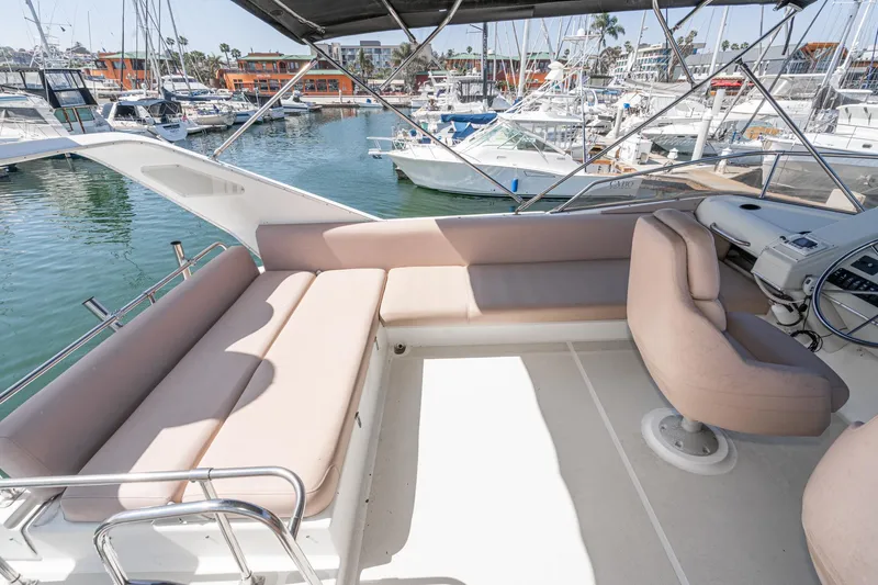 Slide: The Image of 1992 Bayliner 4388 yacht interior with beige seating, docked at a marina. - 16