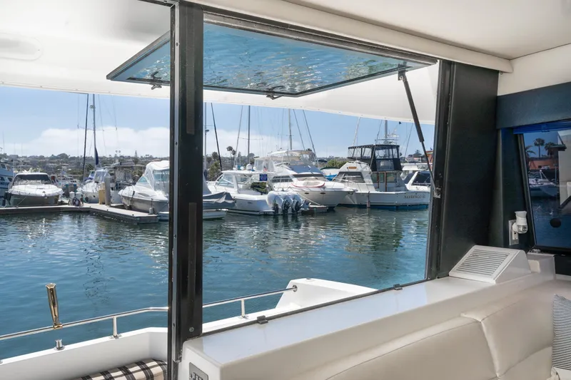 Slide: The Image of Interior view from a 1992 Bayliner 4388 yacht overlooking a marina with boats. - 22