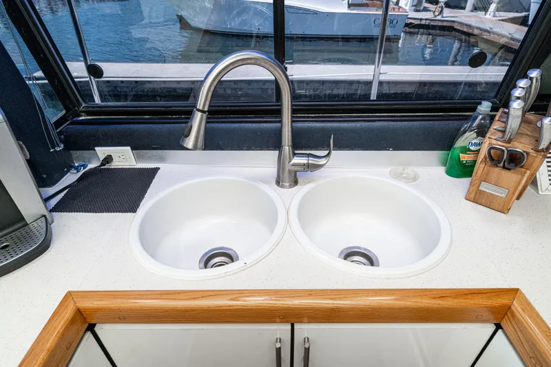 Slide: The Image of Dual sink setup in a 1992 Bayliner 4388 yacht kitchen with a marina view. - 35