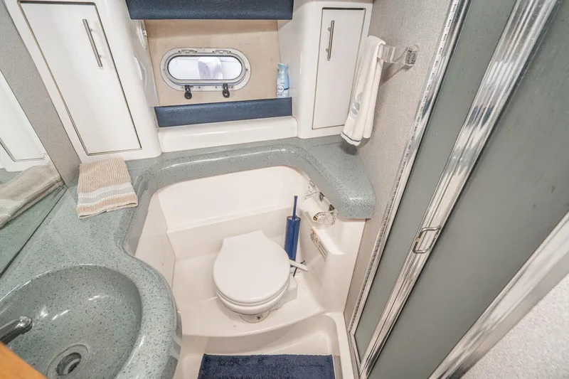Slide: The Image of Bathroom interior of 1992 Bayliner 4388 yacht with sink, toilet, and storage cabinets. - 44