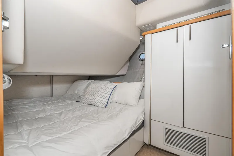 Slide: The Image of Cozy bedroom in 1992 Bayliner 4388 yacht with white bedding and storage cabinets. - 46