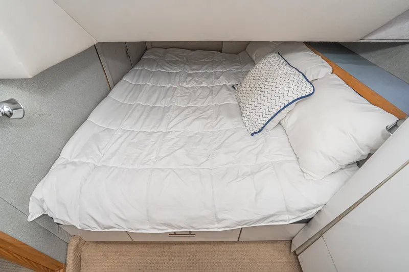 Slide: The Image of Cozy cabin bed in 1992 Bayliner 4388 yacht with white bedding and decorative pillow. - 47