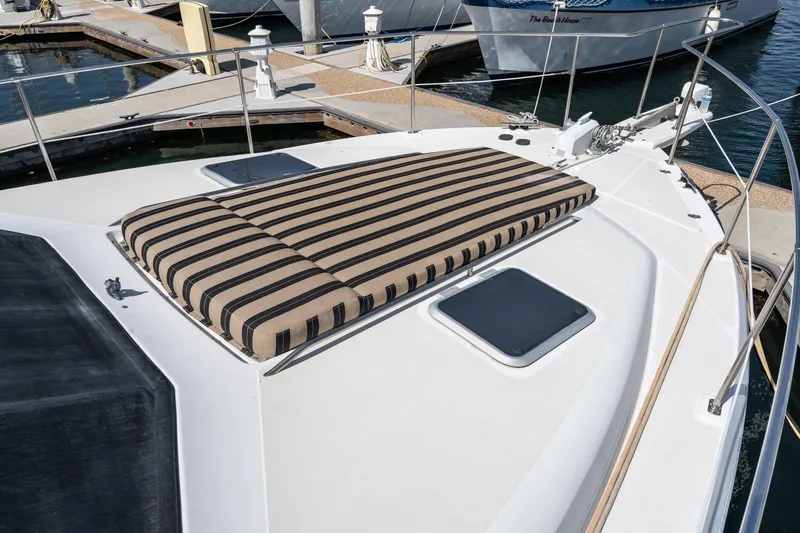Slide: The Image of 1992 Bayliner 4388 yacht with striped sun pad on deck, docked at marina. - 9