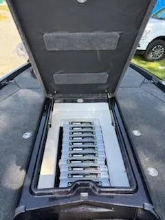 Slide: The Image of Open storage compartment in 2026 Skeeter ZXE20 boat, showcasing organized tackle boxes. - 4