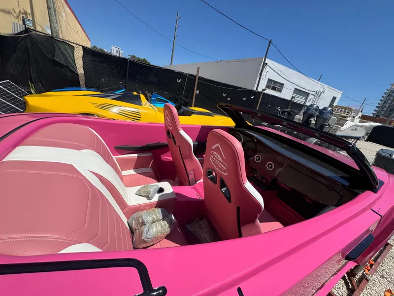 Slide: The Image of Pink Fabbro Jet Car RR 2025 with white interior, parked outdoors under clear blue sky. - 10