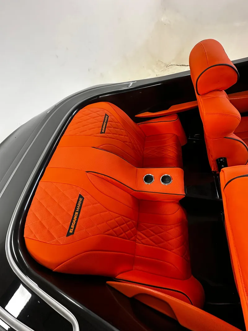 Slide: The Image of Orange leather interior of 2025 Fabbro Jet Car RR, featuring quilted seats and cup holders. - 23