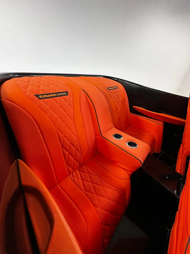 Slide: The Image of Luxurious orange interior of 2025 Fabbro Jet Car RR with quilted seats and cup holders. - 24