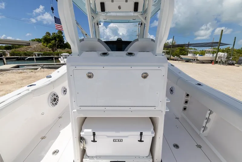 Slide: The Image of 2026 Sea Fox 288 Commander boat interior with Yeti cooler, docked under blue sky. - 11